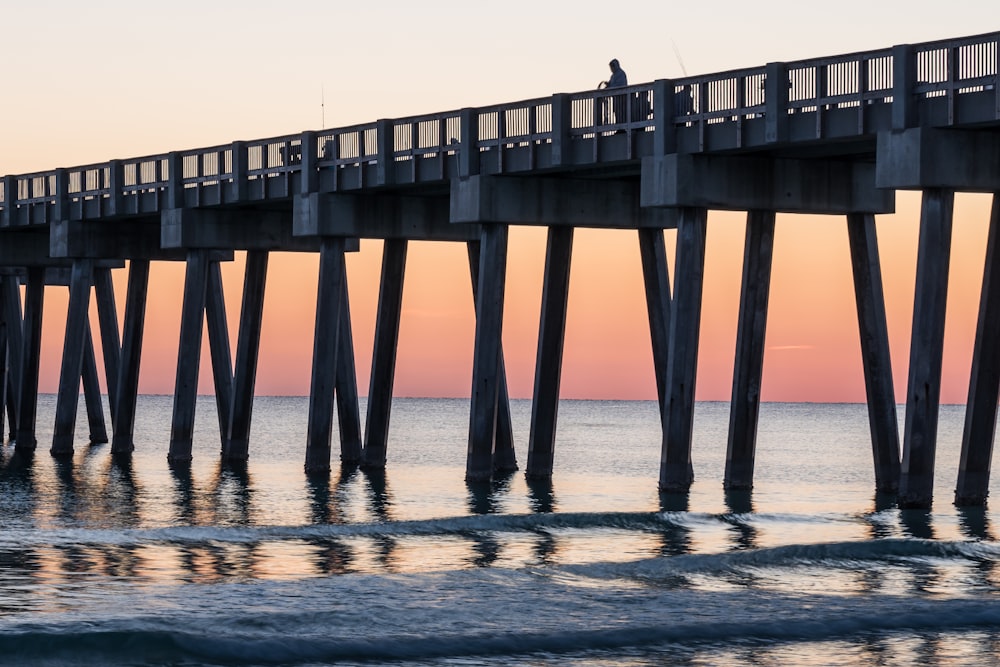 low angle photography of person leaning on dock rail