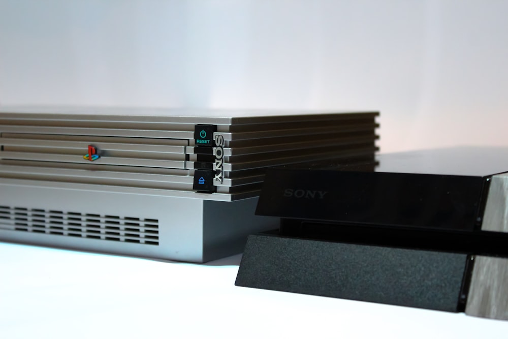 Sony PS2 beside PS4 consoles