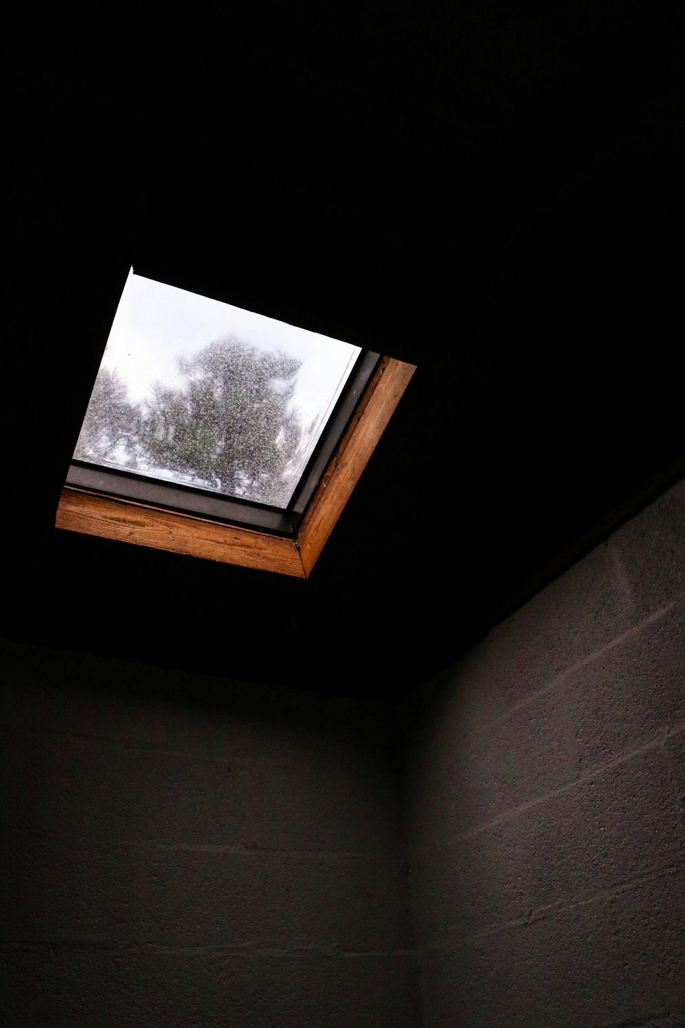 braune Betonwand unter dem Dachfenster im Zimmer