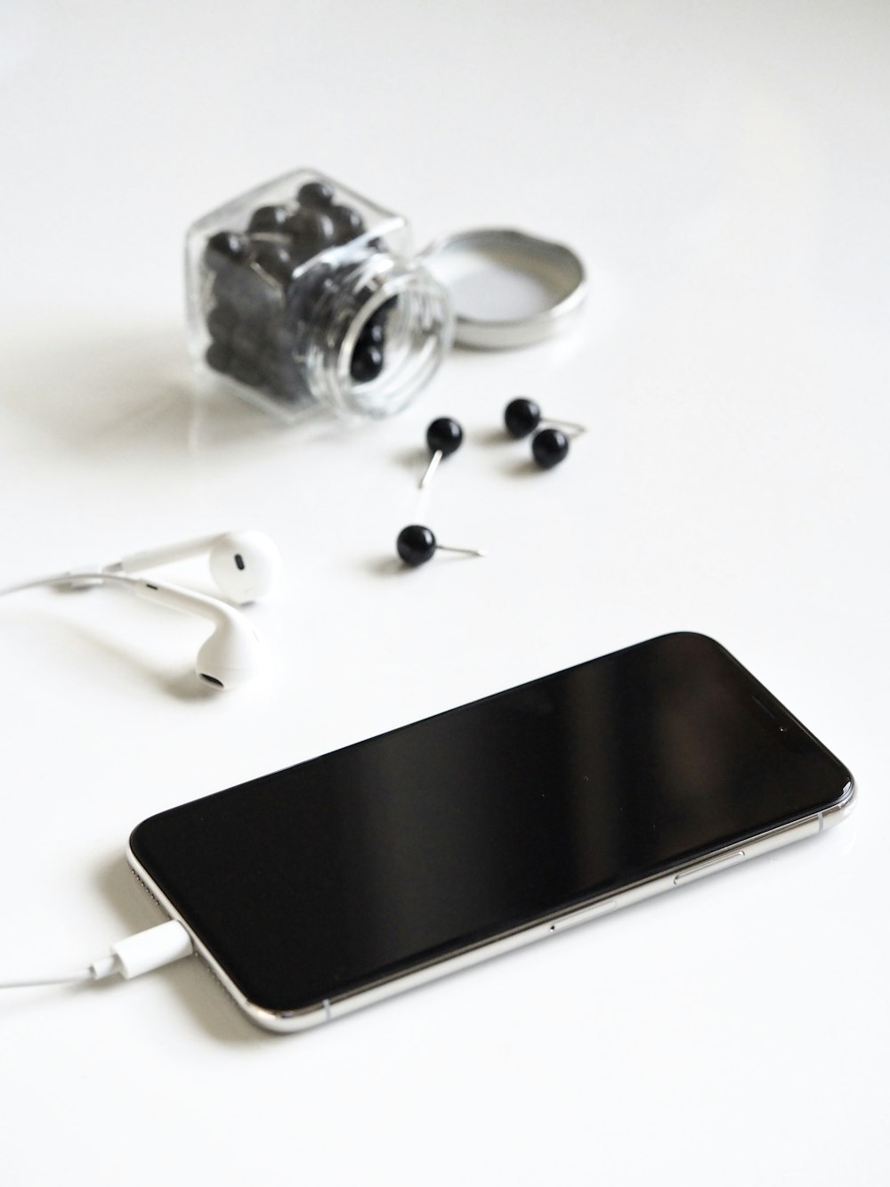 um telefone celular e fones de ouvido em uma mesa