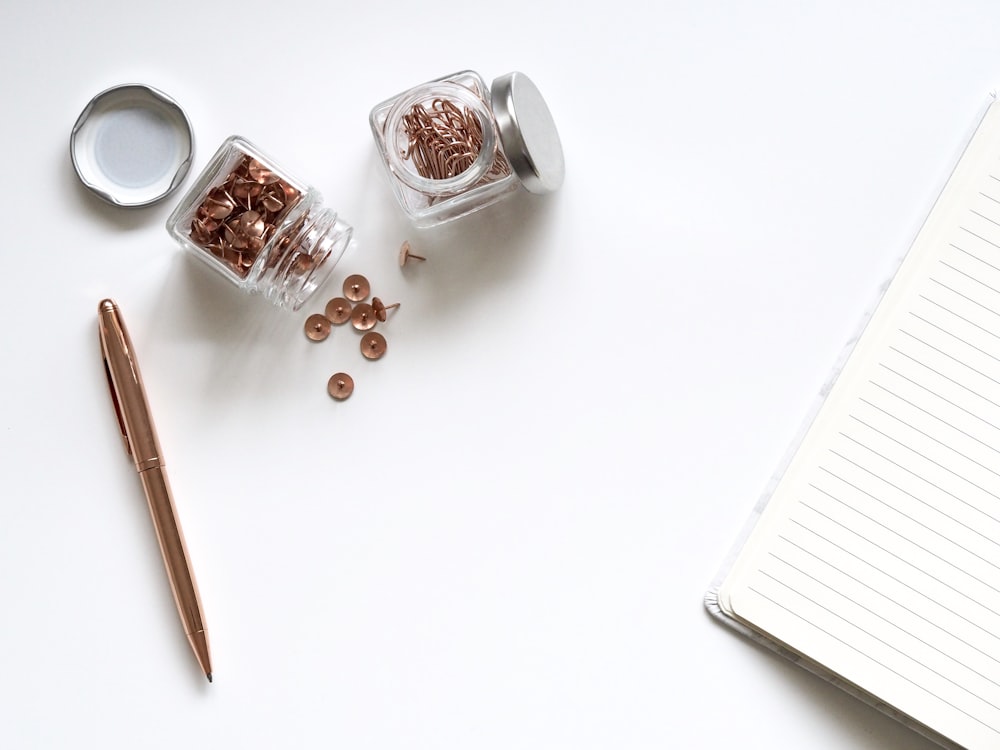 stainless steel twist pen beside clear glass jars