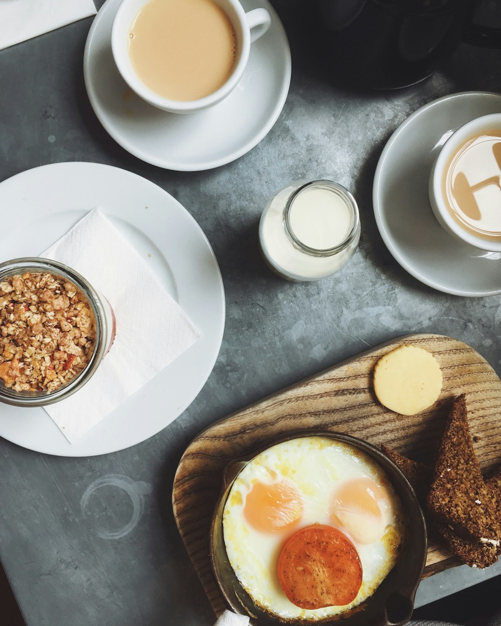 sunny side-up egg on plate beside white plates