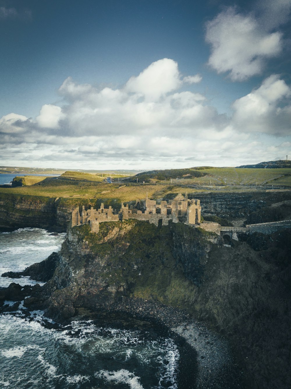 Castillo de hormigón en un acantilado cerca de la masa de agua durante el día