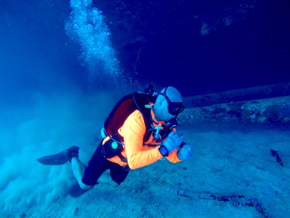 person wearing yellow top diving on water