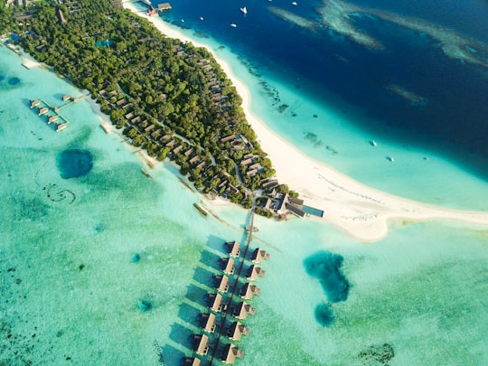 aerial shot of nipa huts on body of water near island in Four Seasons Resort Maldives at Landaa Giraavaru Maldives