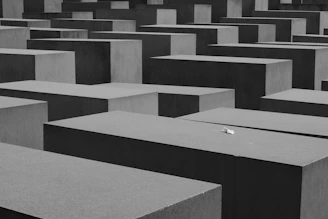 Abstract black and white grid overlay on a smooth concrete surface, evoking order and precision.