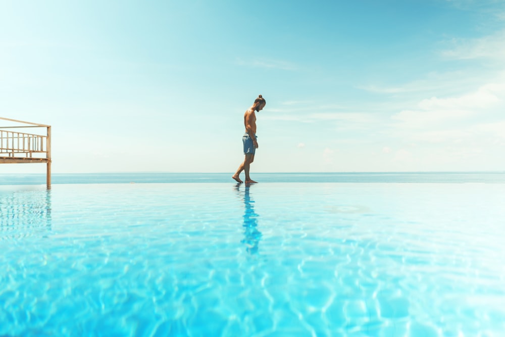 uomo che cammina sullo specchio d'acqua durante il giorno