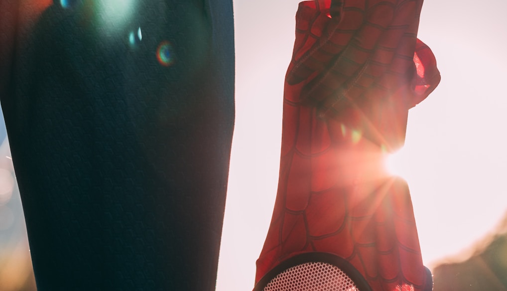 person holding Spider-Man mask