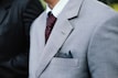 man wearing gray notched lapel suit jacket standing