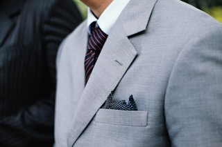 man wearing gray notched lapel suit jacket standing