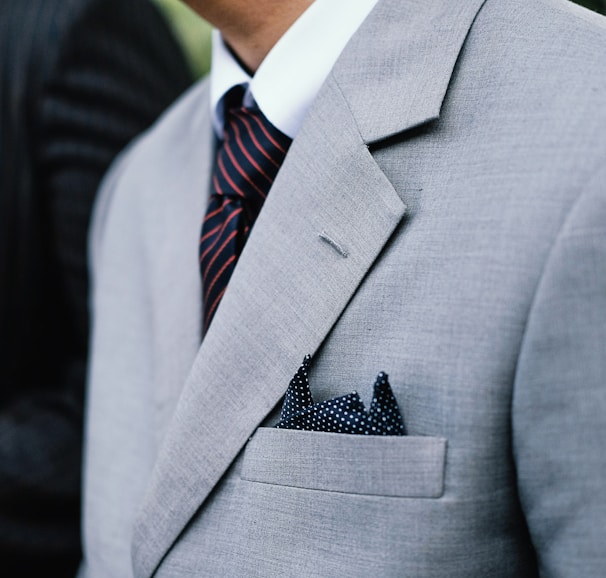 man wearing gray notched lapel suit jacket standing