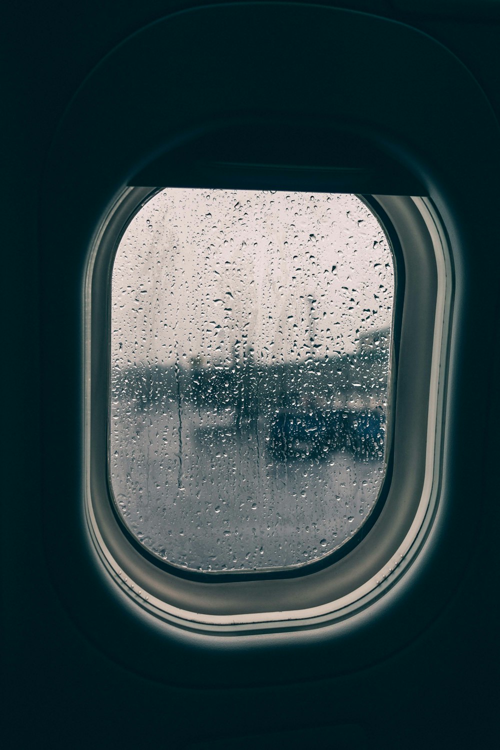 clear glass plane window full of rain droplets