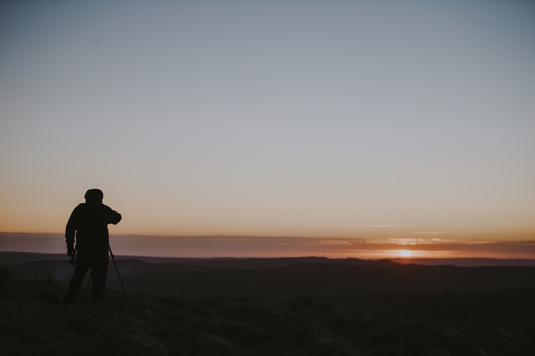 man watching aerial view of mountain and sunset