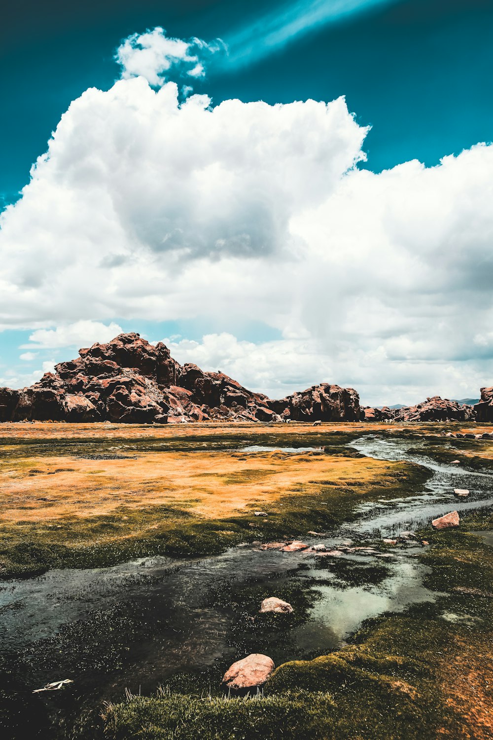 body of water under white clouds and blue sky