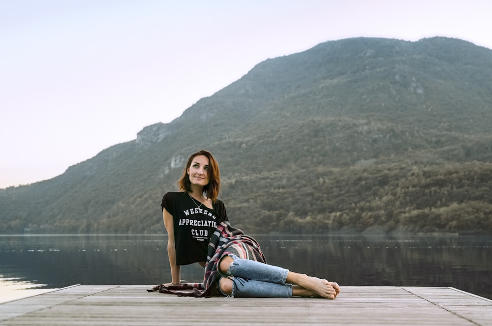 woman posing on dock located across the mountain