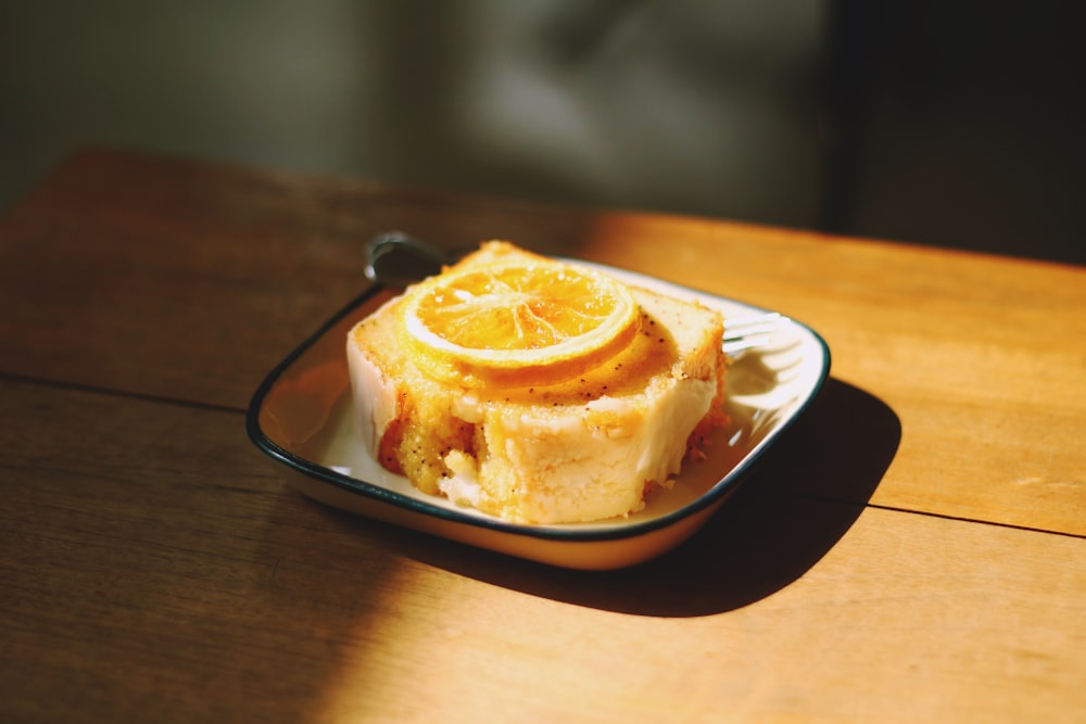 citron tranché sur le dessus d’un gâteau tranché sur une assiette en céramique blanche