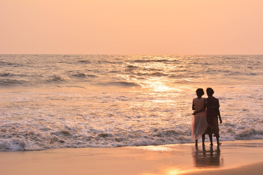 two women standing on shoreline