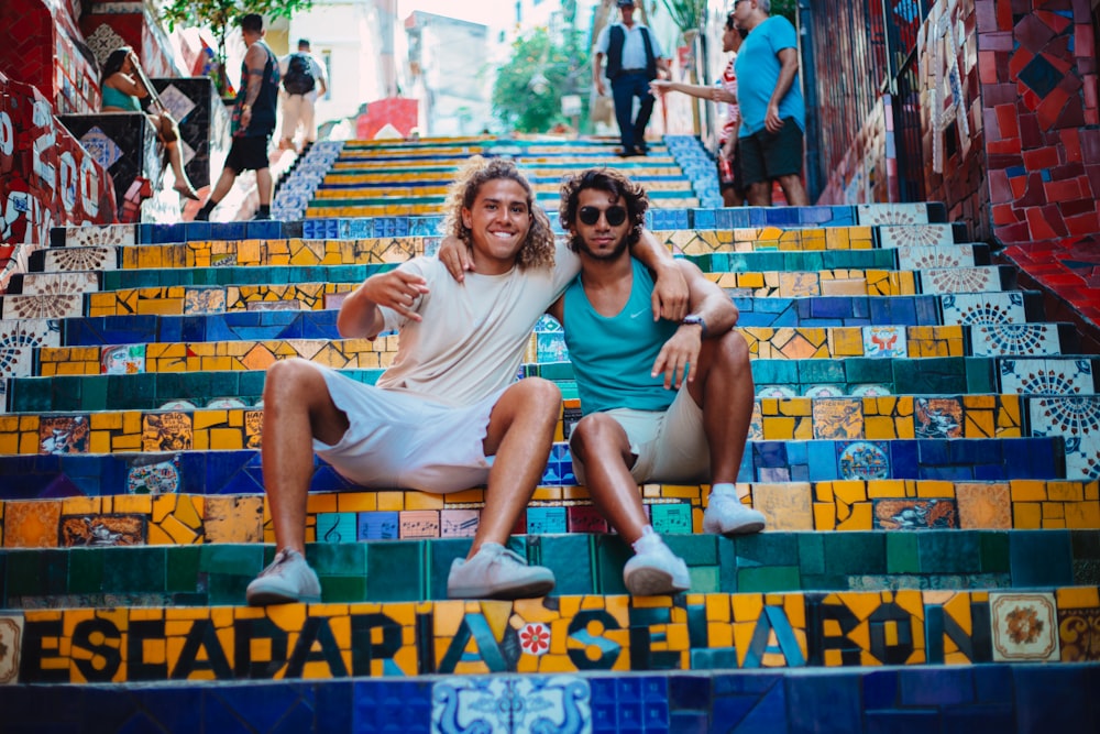 men sitting on concrete stair during daytme