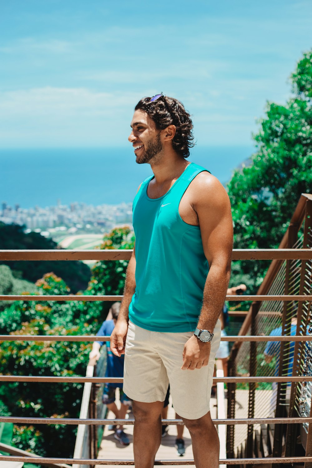 man in teal tank top standing