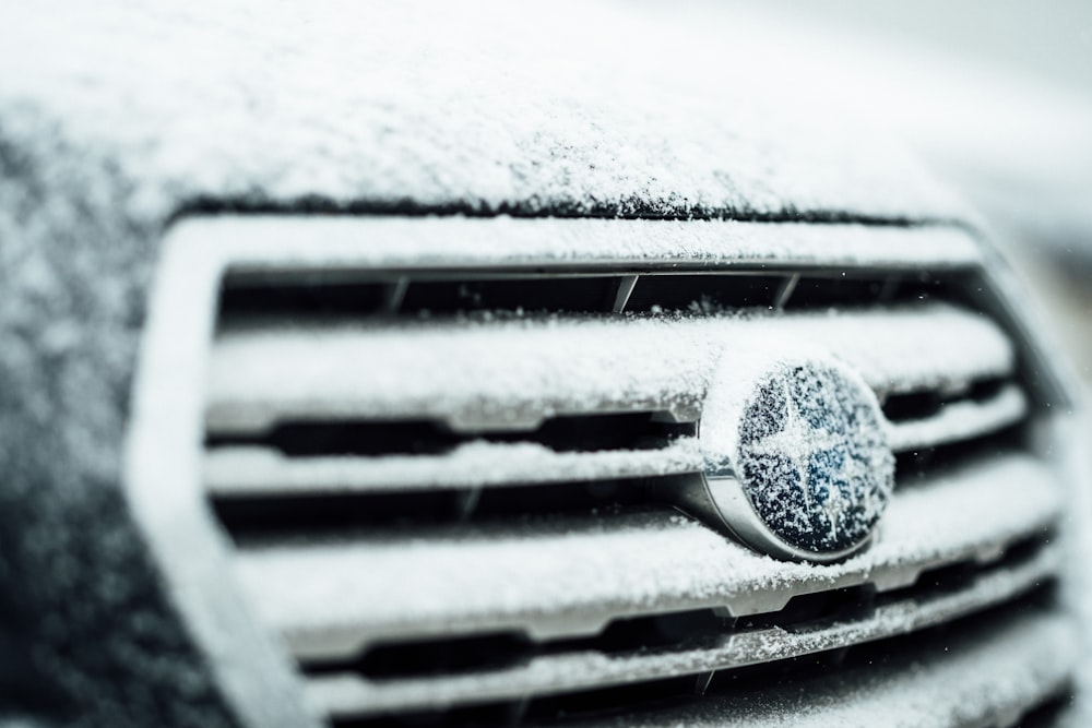 selective-focus photography of black Subaru emblem