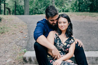 man wearing blue dress shirt and black pants and woman in black floral dress