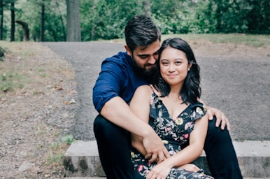 man wearing blue dress shirt and black pants and woman in black floral dress