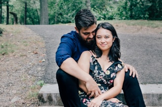 man wearing blue dress shirt and black pants and woman in black floral dress