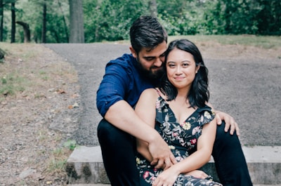 man wearing blue dress shirt and black pants and woman in black floral dress