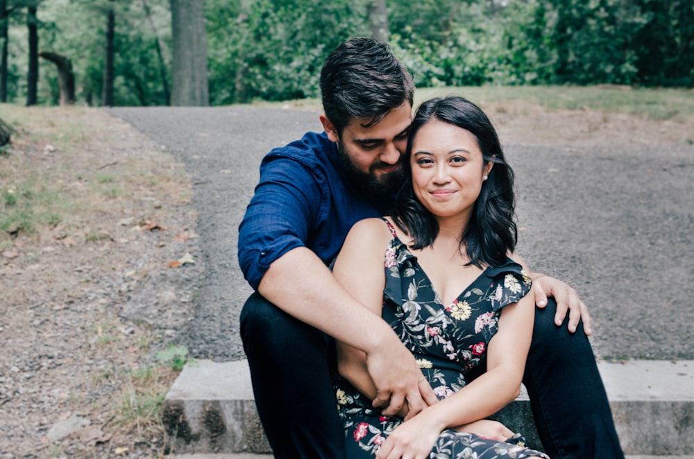 man wearing blue dress shirt and black pants and woman in black floral dress