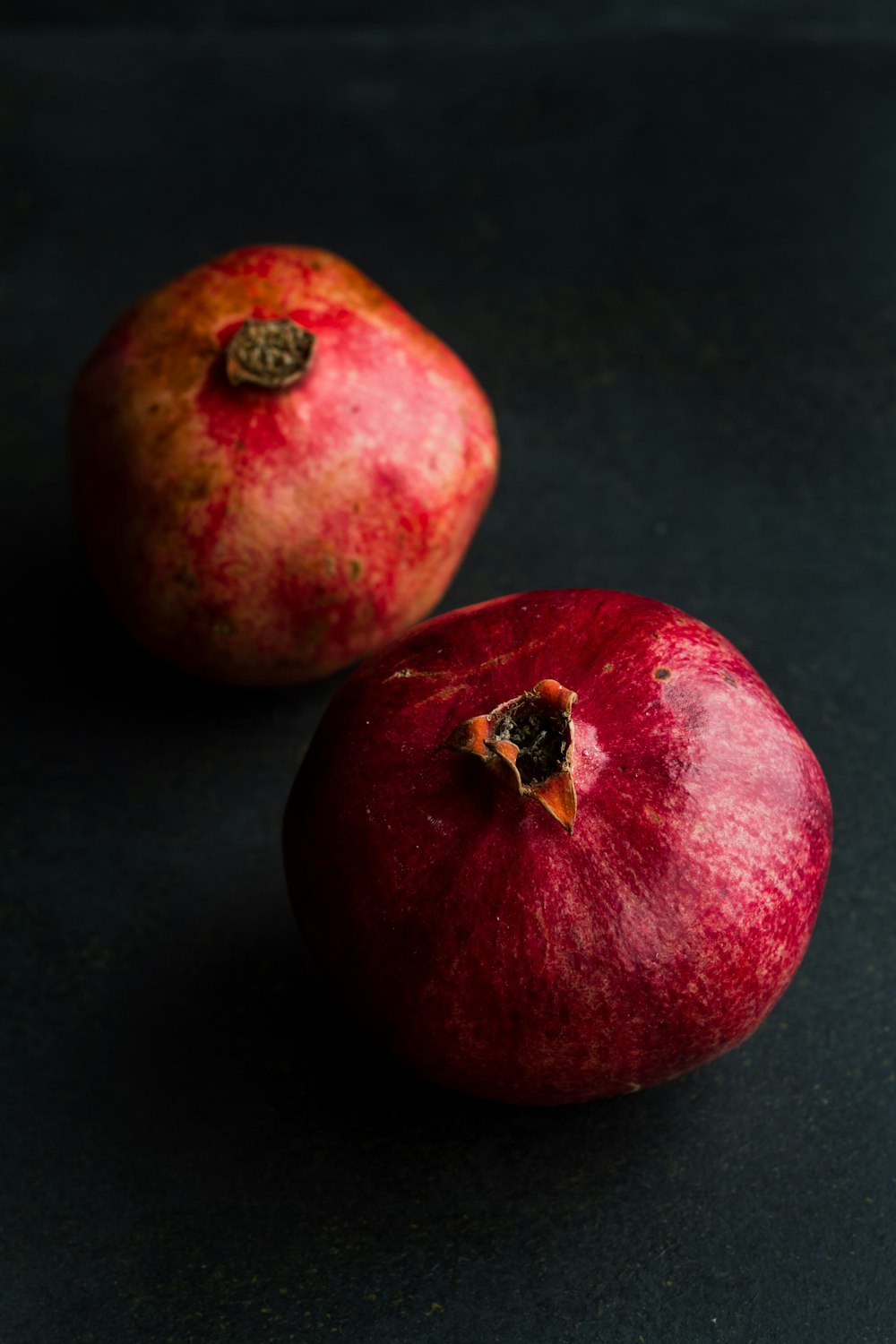 Un par de manzanas rojas sentadas encima de una mesa