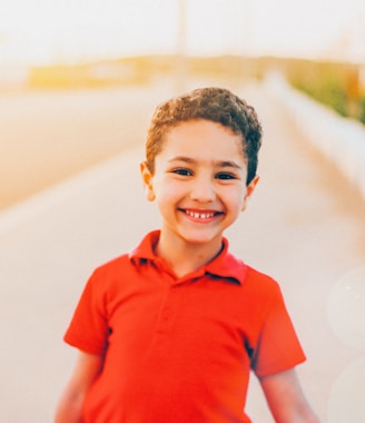 smiling boy wearing red polo shirt