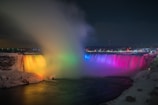 Niagara Falls with lights and overlooking view of buildings during nighttime