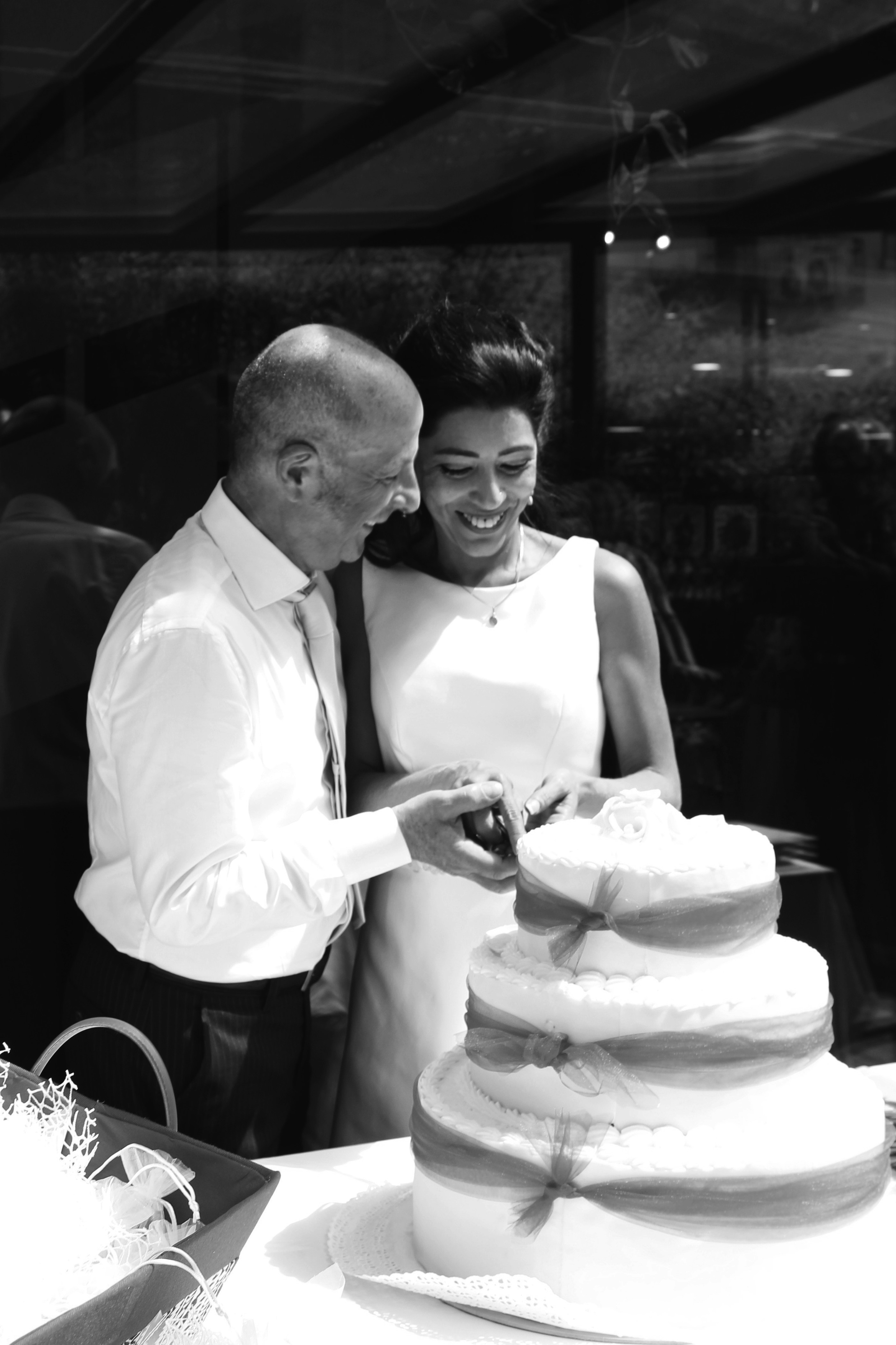 Wedding cake cutting ceremony, couple laughing