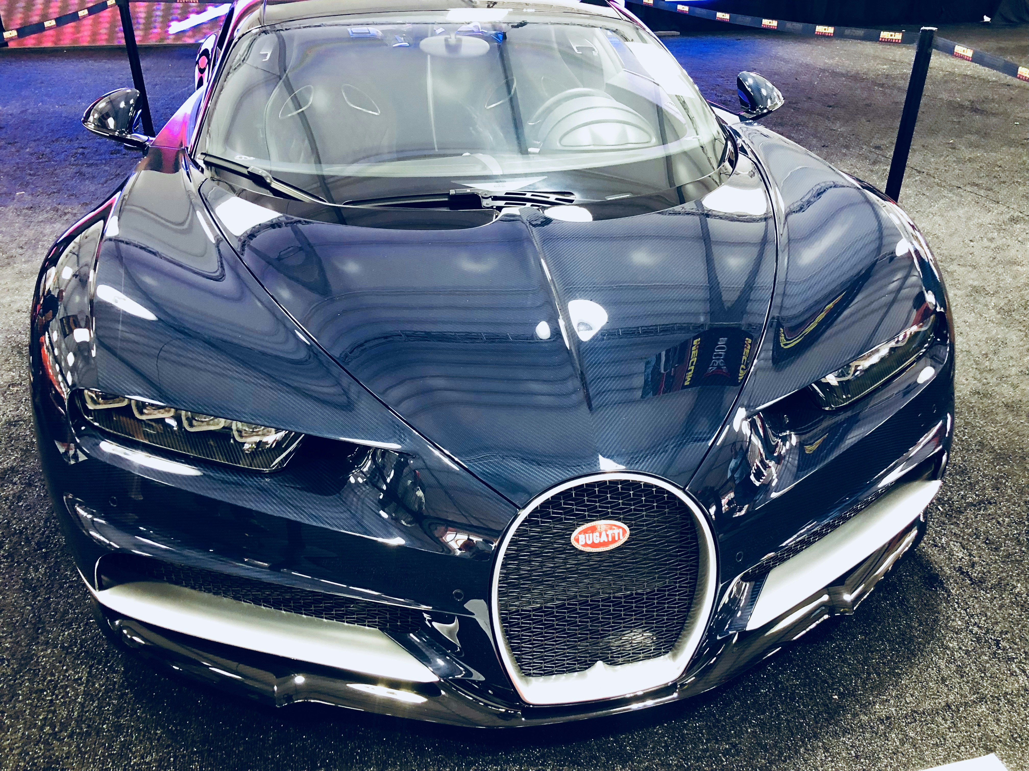 Blue Bugatti Chiron on closed road, dramatic low angle shot, hypercar horseshoe grille prominent