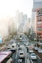 highway road filled with cars surrounded by high rise buildings