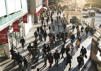 aerial photography of people walking on sidewalk near building during daytime