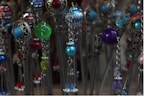 A collection of intricate hairpins features colorful beads and ornate metallic designs. The beads are in various colors including blue, green, red, and purple, and are paired with silver metalwork that adds an elegant touch.