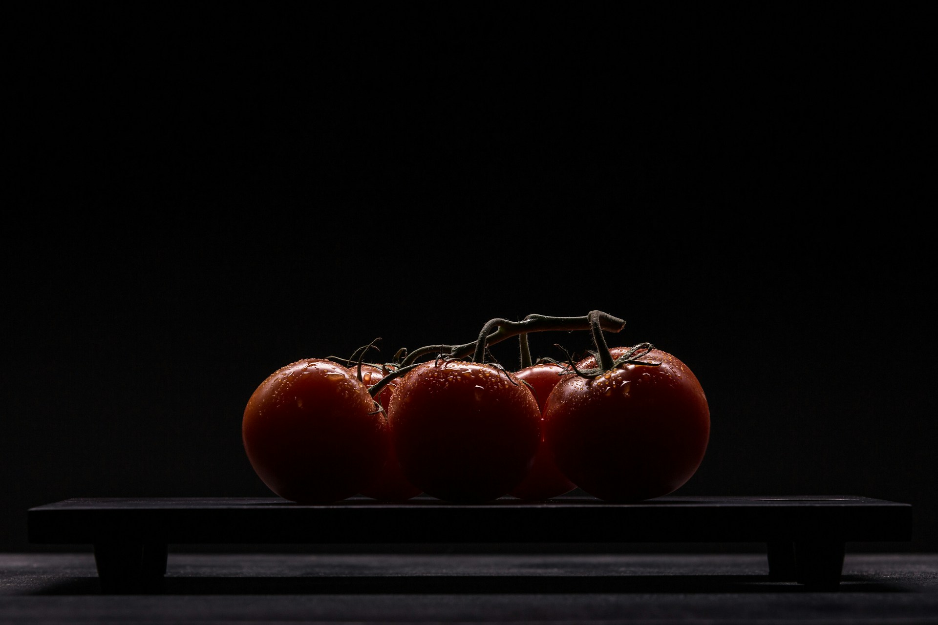 red tomatoes on black surface