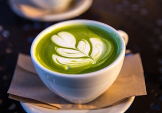 white ceramic teacup filled of matcha tea