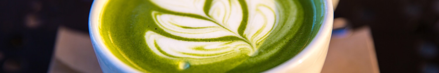 white ceramic teacup filled of matcha tea