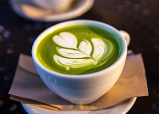 white ceramic teacup filled of matcha tea