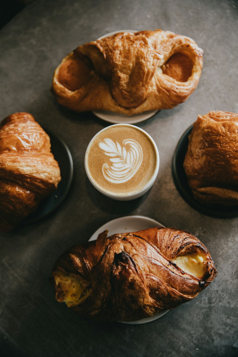 coffee surrounded by four baked breads