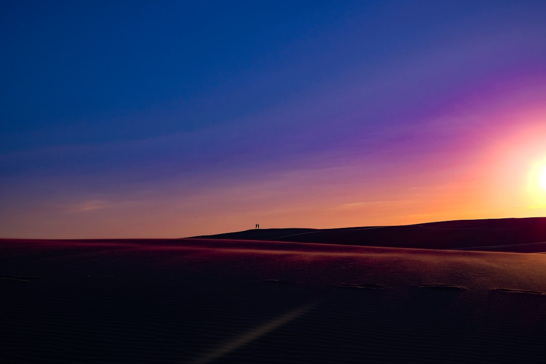 silhouette on two persons on dune