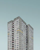 A panoramic view of a completed 12-story residential tower with clean lines and modern design.