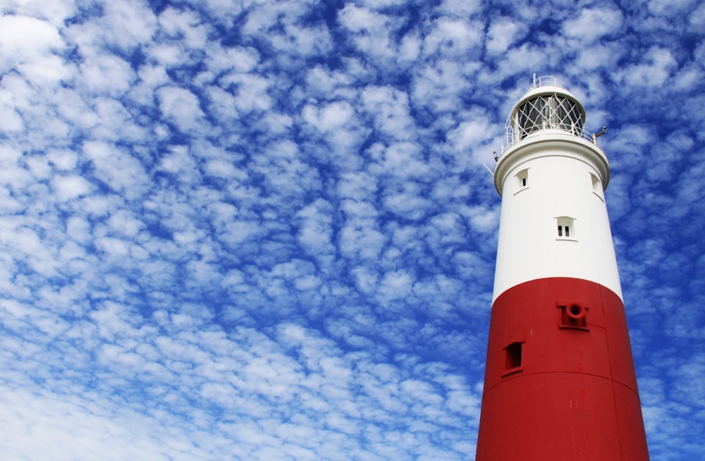 white and red lighthouse under cloudy sky