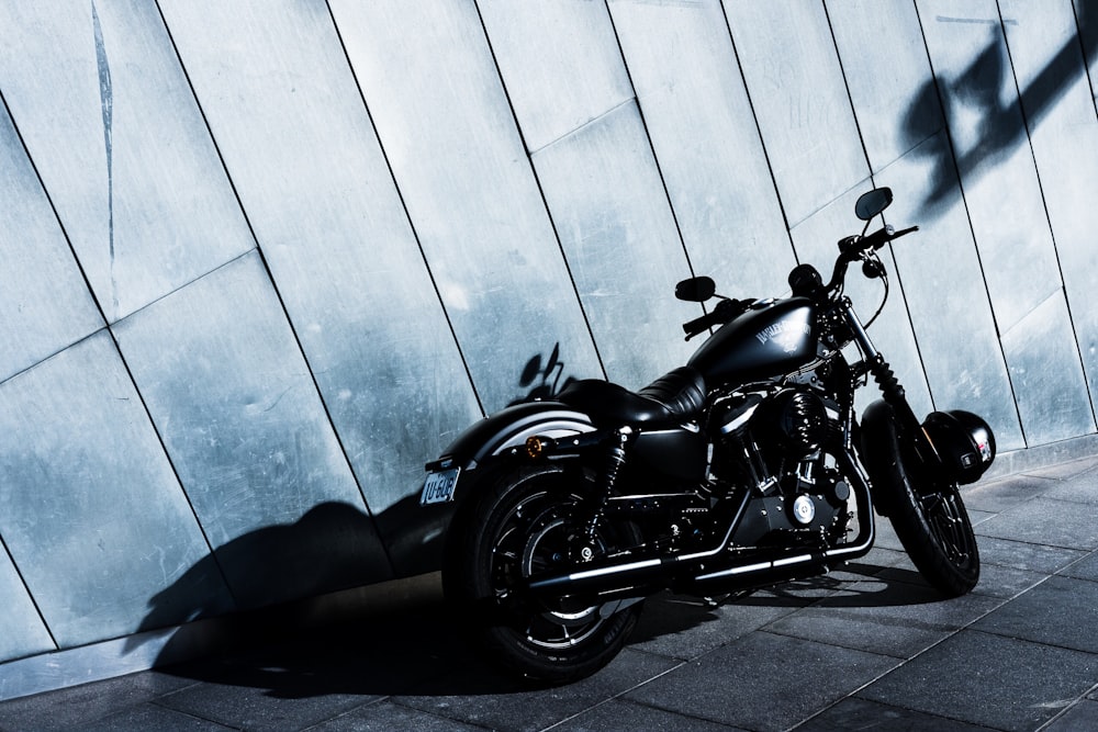 a black motorcycle parked in front of a wall