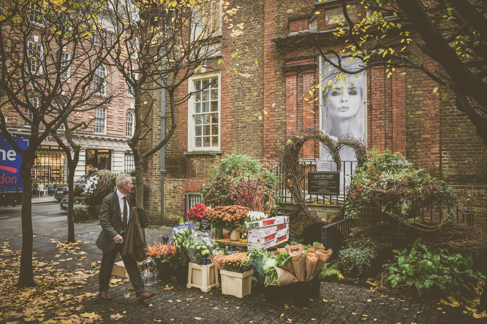 Nikon D3400 + Nikon AF-S DX Nikkor 18-55mm F3.5-5.6G II sample photo. Man walking beside flowershop photography