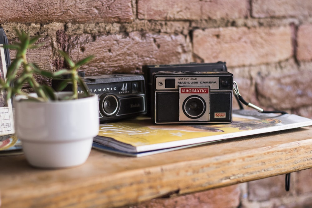 black and gray camera near white ceramic plant pot