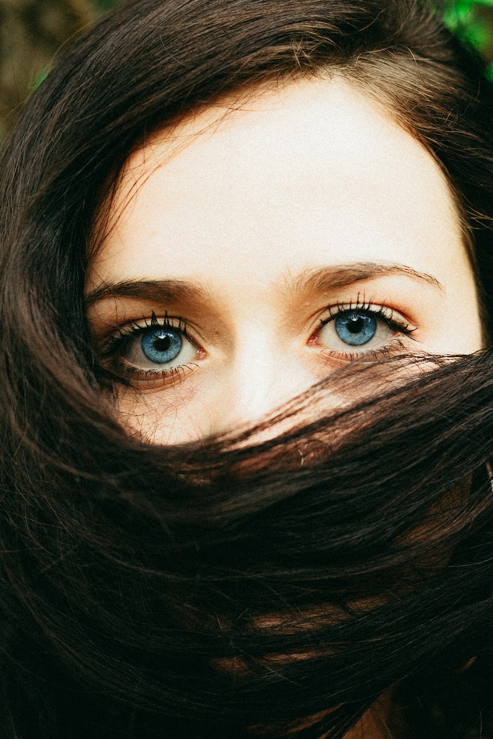 髪の毛で顔を覆う女性の肖像写真