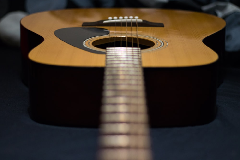 Fotografia tilt-shift da guitarra acústica marrom